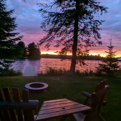 Outdoor grilling and dining area at Smile Awhile, ideal for summer BBQs and family meals surrounded by nature and tall pines.